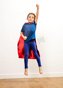 功能强大的超级英雄男孩跳得高，达到自由的披肩