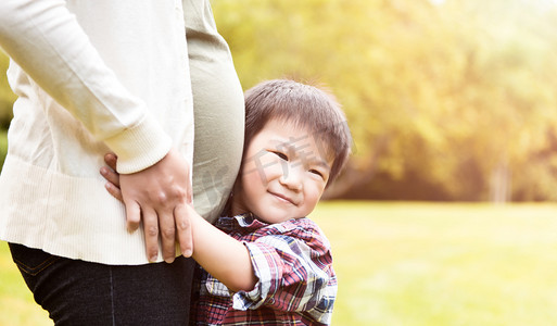 宝宝肚子痛摄影照片_亚洲孕妇和她的儿子