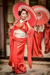 艺伎摄影照片_在与阳伞红色和服的艺妓