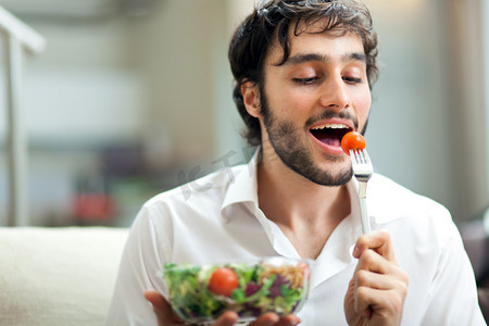 采蔬菜摄影照片_年轻男子吃健康的沙拉