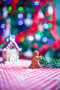 姜饼人背景糖果姜房子和圣诞树灯的特写镜头