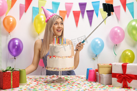 年轻妇女庆祝她的生日和拿着棍子自拍