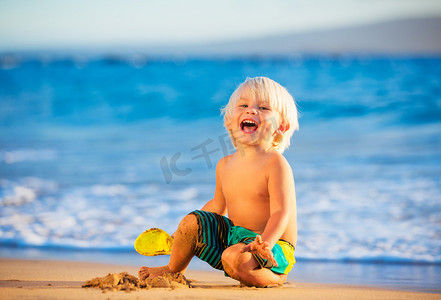 你的快乐童年摄影照片_年轻的男孩在海边玩