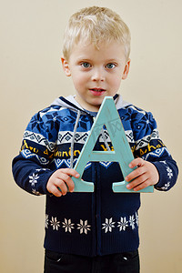 蓝色教学摄影照片_蹒跚学步的男孩与字母 A