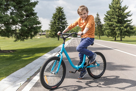 男孩骑摄影照片_微笑的孩子男孩骑自行车