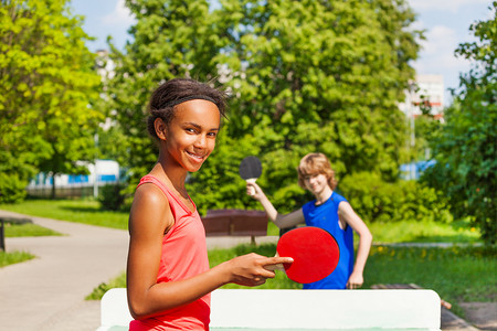非洲女孩玩乒乓与男孩在外面