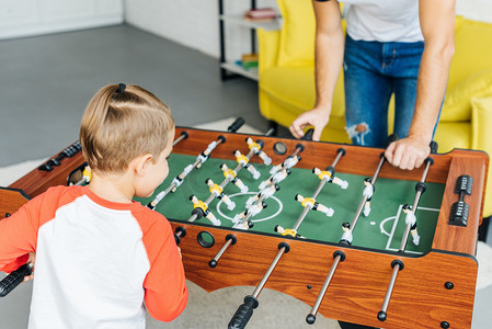 观点摄影照片_父亲和儿子的部分观点在家里玩桌上足球