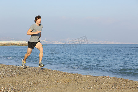 慢跑者在水附近的海滩上运行