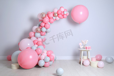 气球装饰背景墙摄影照片_轻墙附近有气球和糖果的优美构图
