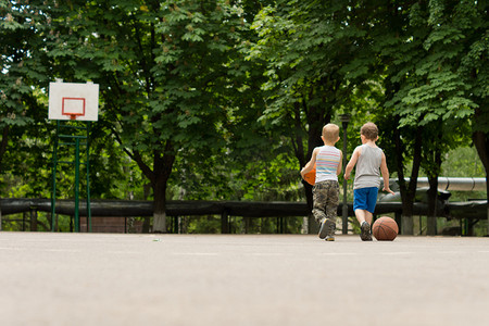 走出一个篮球场的两个小男孩