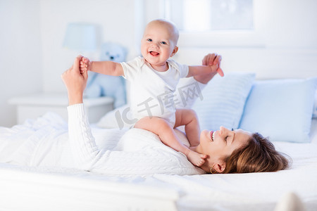 海产品单张摄影照片_妈妈和宝宝在白色的床上