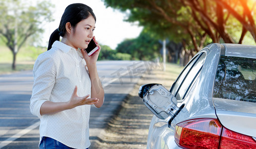 车油向下和年轻的女人试图打电话求救电话