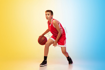 渐变活动摄影照片_具有渐变背景的年轻篮球运动员的全长肖像