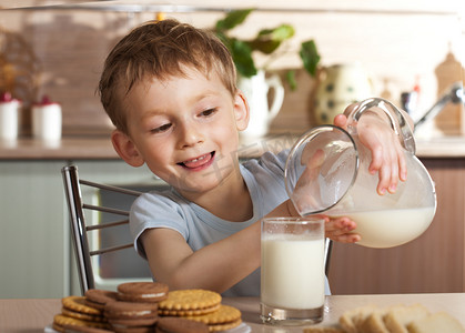 健康的孩子倒牛奶从水罐