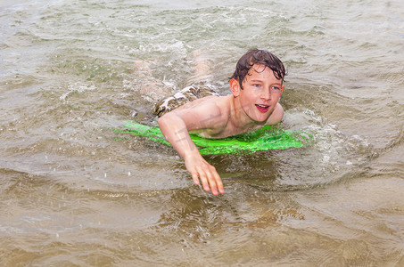 快乐的孩子享受在浪中冲浪