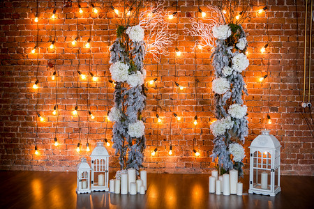 树枝灯笼摄影照片_有绣球花灌木, 蜡烛和灯泡在砖背景的针叶树枝