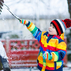 在丰富多彩的冬天的衣服出去玩堆雪人，小男孩