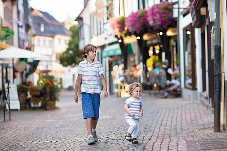 哥哥和他的小婴儿妹妹散步、 玩耍在一条购物街