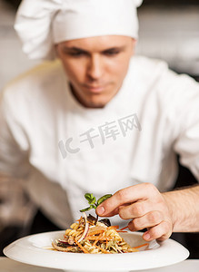 厨师真好吃摄影照片_厨师装饰意大利面沙拉配草药叶