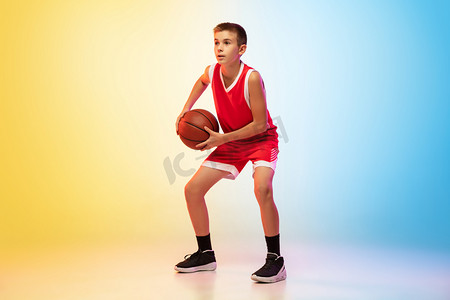 帅气男孩子摄影照片_具有渐变背景的年轻篮球运动员的全长肖像