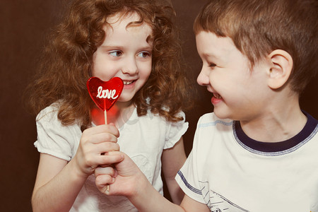 情定摄影照片_快乐的男孩和女孩与一个甜甜的棒棒糖.