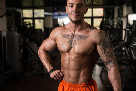 人体男肌肉摄影照片_展示肌肉在健身房的肌肉男