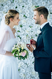 玫瑰摄影照片_新郎提出新娘婚纱建议侧视图 
