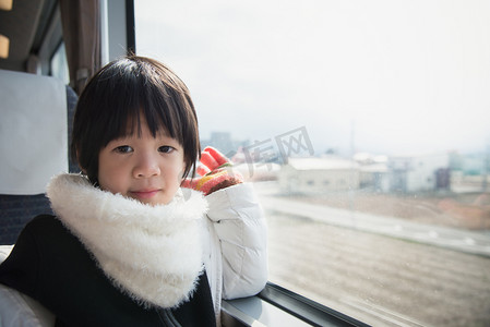 快乐的亚洲孩子，望向窗外火车