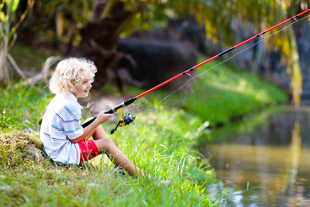 男孩钓鱼。孩子用棍子在河里抓鱼