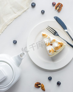 煮茶茶壶摄影照片_白色桌上的甜饼和茶壶的开胃蛋糕的顶部视图