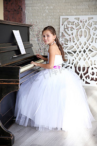 公主的女孩穿着弹钢琴