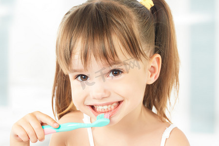 科技小子摄影照片_快乐的小女孩，她刷牙