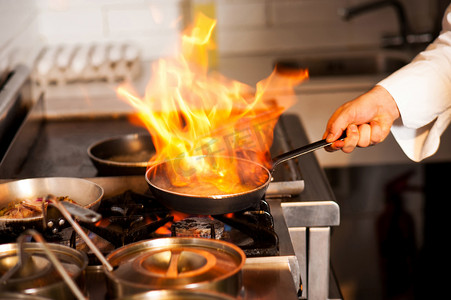 火锅摄影照片_在厨房炉灶做饭的厨师