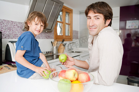 单页摄影照片_爸爸带着儿子一起在自家的厨房