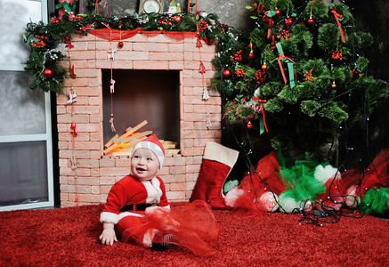 冬季的心情摄影照片_小男孩打扮成圣诞老人。在背面的西装