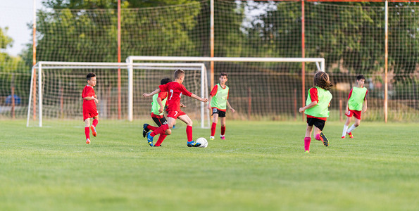 游戏比赛对决摄影照片_孩子足球-足球场儿童球员比赛 