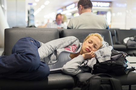 国家行动方案摄影照片_累了女性旅行者在机场睡觉.