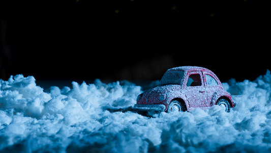新年雪地摄影照片_在夜间站在雪地里的微型汽车的特写镜头