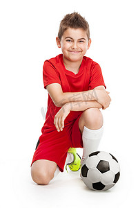 跪着足球的年轻足球运动员