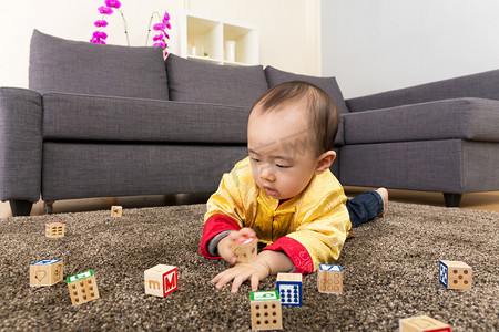 亚洲第一摄影照片_中国小男孩玩玩具块和躺在地毯上