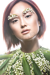 时尚漂亮的女孩东方型精致自然化妆和鲜花。美丽的脸. 