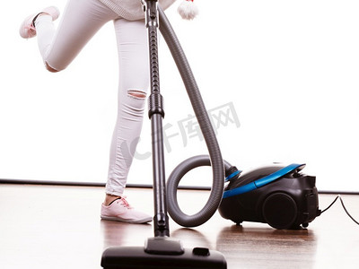 家居清洁工具和设备，家政职责的概念。女人的腿和吸尘器。女人的腿和吸尘器