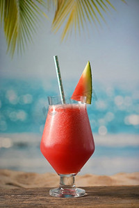 在海滩上喝一杯新鲜的西瓜汁