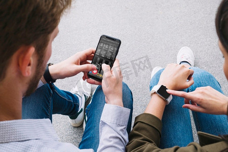 朋友坐在街上连接智能手表与手机