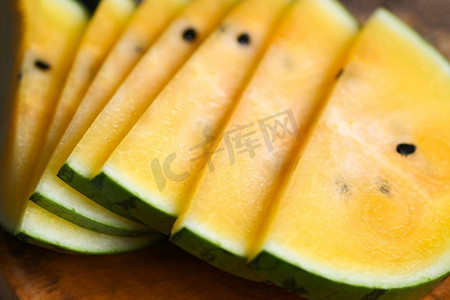 甜的西瓜片片新鲜的西瓜热带夏天水果，黄色西瓜片在木背景