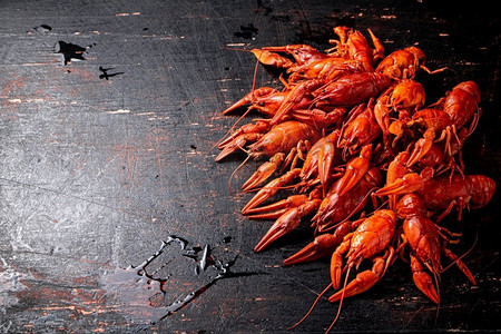 桌上有一堆煮好的小龙虾。在黑暗的背景下。高质量的照片。桌上有一堆煮好的小龙虾。 