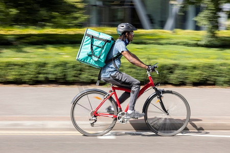 骑自行车在城市送外卖的快递员