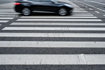 人行横道摄影照片_人行横道与模糊汽车的人行横道在柏油路在街道。人行横道人行横道在街上