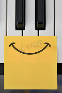 抽象拍摄的钢琴键盘和绘制快乐的微笑注意