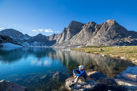 一个人在平静的湖边安心休息.湖泊山峦